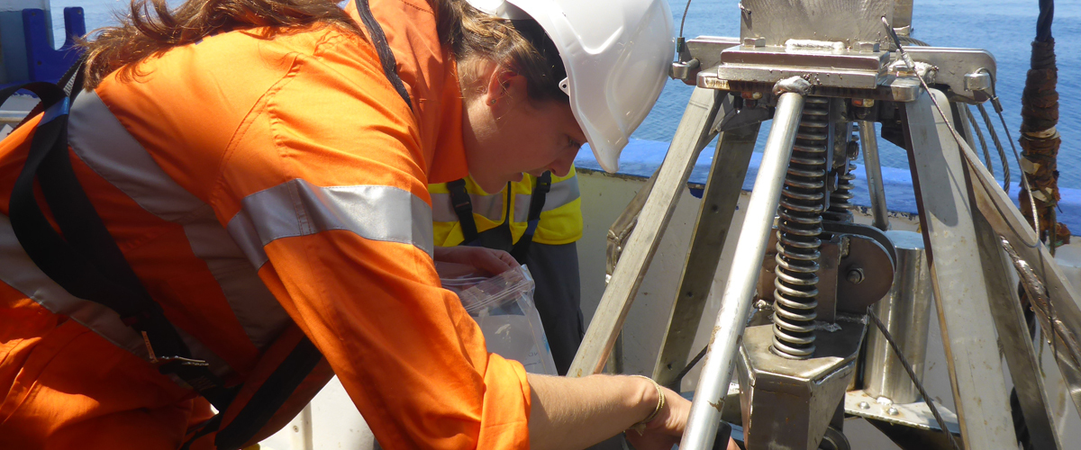 A scientist adjusting sediment sampling equipment
