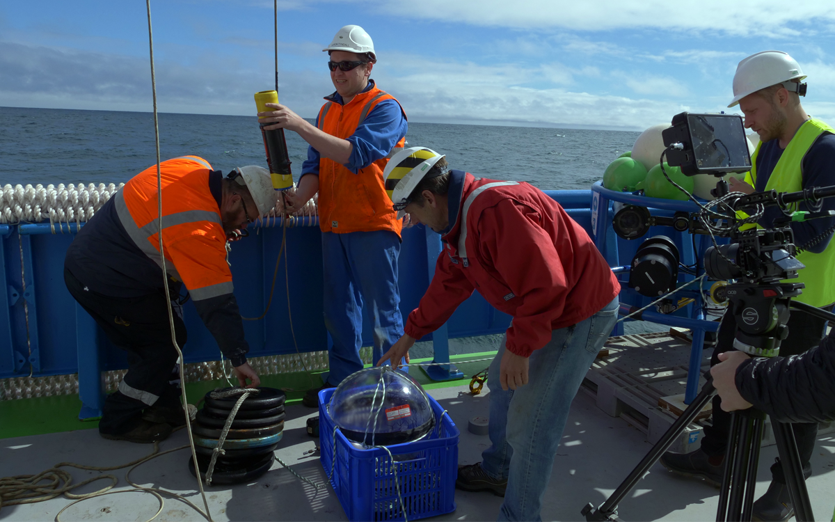 Scientists and crew setting up an acoustics experiment