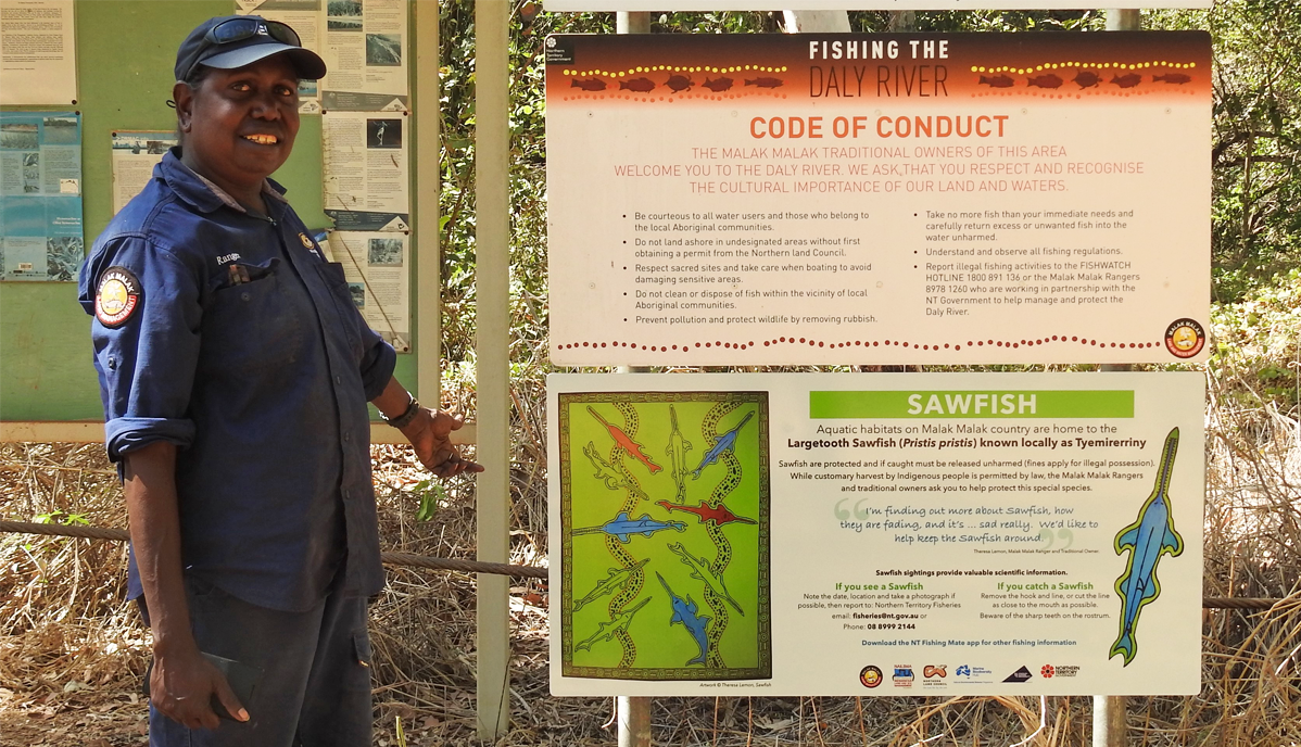 A Malak Malak ranger with a sawfish sign at Woolianna boat ramp on the Daly River.